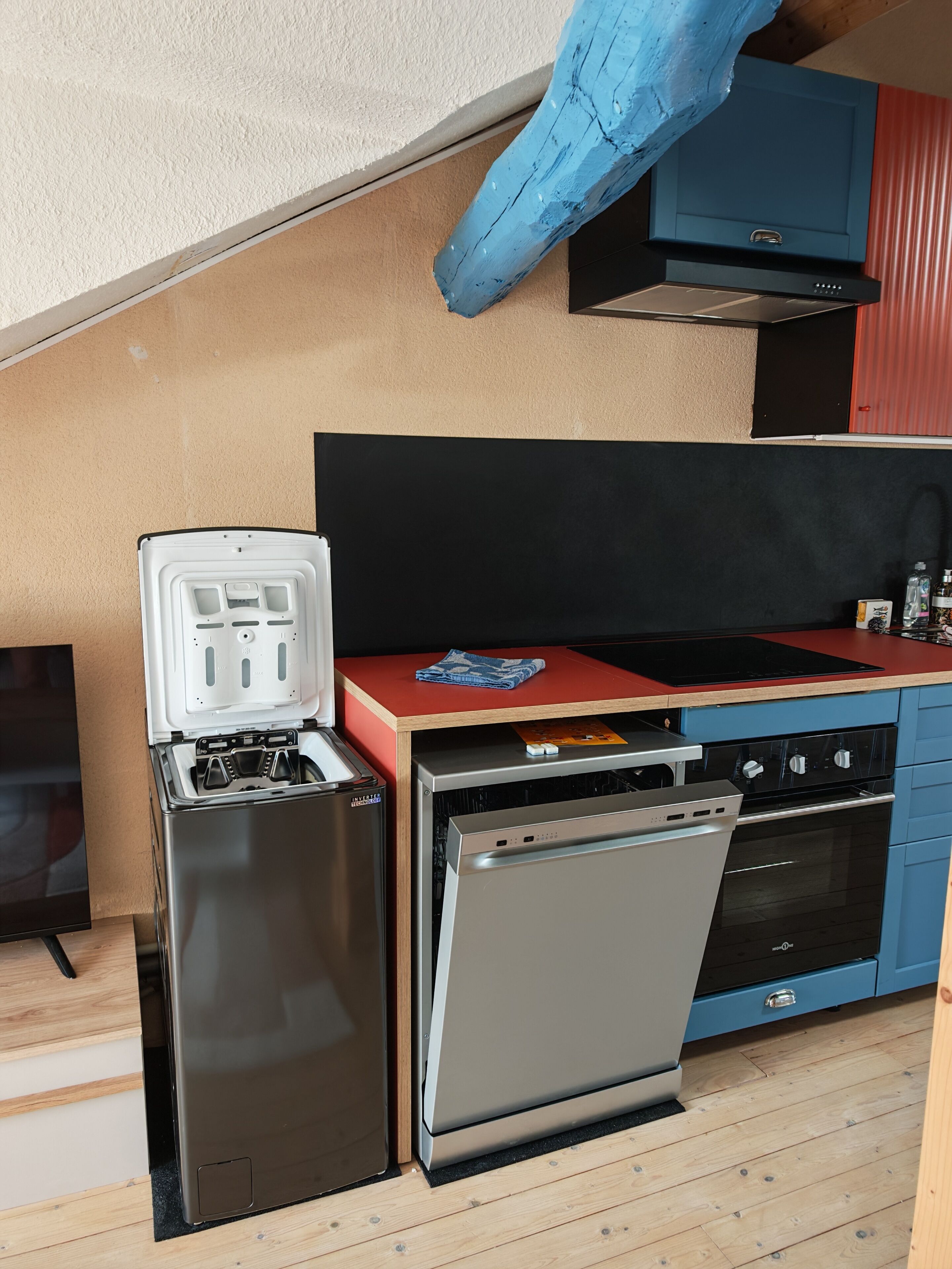 A compact kitchenette with a built-in refrigerator, dishwasher, and stove.