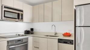 A modern kitchen with stainless steel appliances, a built-in microwave, and a dishwasher. - 1BR, Marina & Bay View, High Floor, Resort (Hallandale Beach)