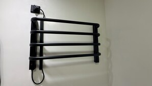 Un porte-serviettes noir fixé à un mur blanc.