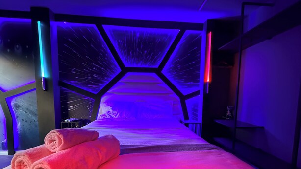 Une chambre dotée d’un lit, de serviettes et d’un décor de plafond original.