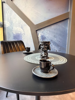 A round table with a coaster, a mug, and a decorative item. - Studio apartment - the comfortable side of the force (São Paulo)