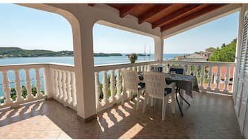 Un espacio de estar al aire libre techado con vistas a un lago y colinas.