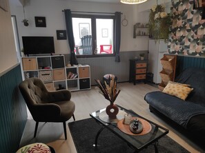 A living room with a sofa, armchair, coffee table, and a TV. - Small, quiet vacation home (Bretignolles-sur-Mer)