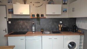 Eine moderne Küche mit Geschirrspüler, Waschmaschine und Kaffeemaschine.