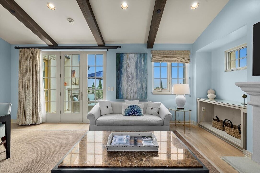 A living room with a sofa, coffee table, and a painting on the wall.