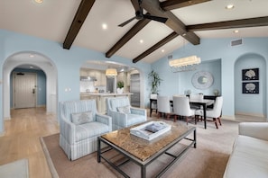 Amplia sala de estar con techo alto, cocina integrada y comedor.