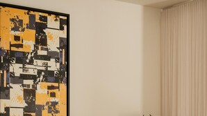 Un saló modern amb un sofà, una taula de centre, una biblioteca i un quadre abstracte gran.
