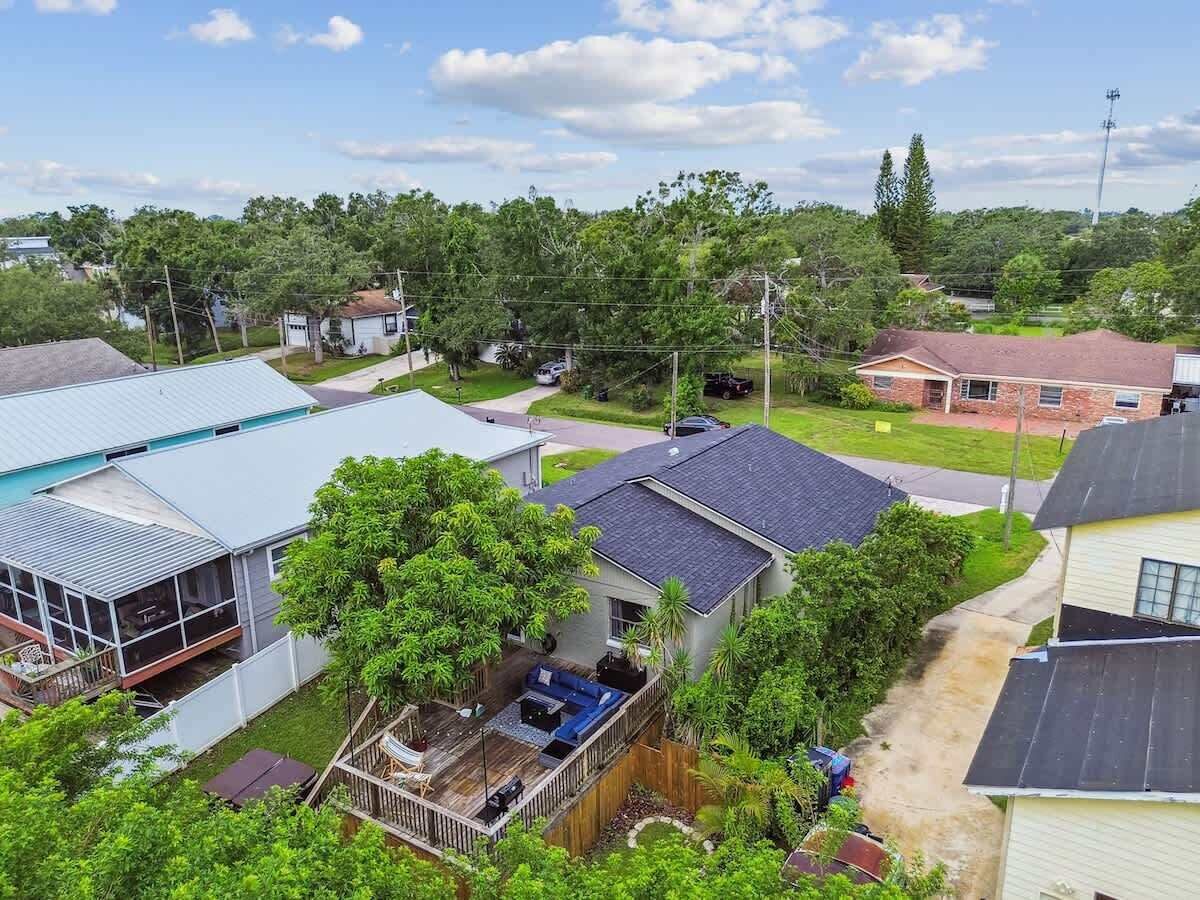 Un quartier résidentiel comprenant plusieurs maisons, un espace extérieur couvert avec un barbecue et une cour clôturée.