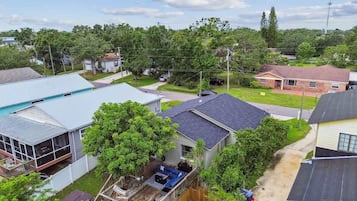 Un quartier résidentiel comprenant plusieurs maisons, un espace extérieur couvert avec un barbecue et une cour clôturée.