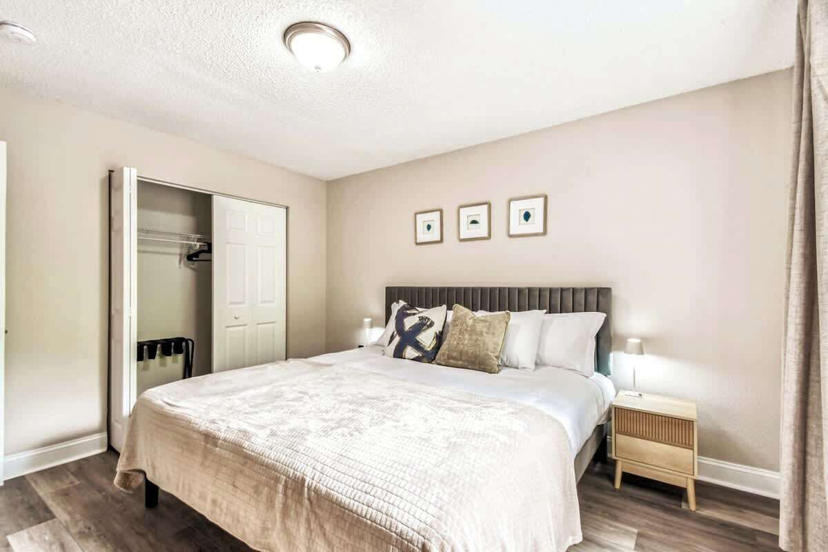 A bedroom with a bed, bedside table, nightstand, wardrobe, and a ceiling light.