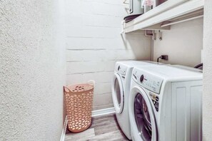 A laundry area with two washing machines and a laundry basket. - S Tampa 3BR | Hot Tub, Fire Pit, Near MacDill (Tampa)