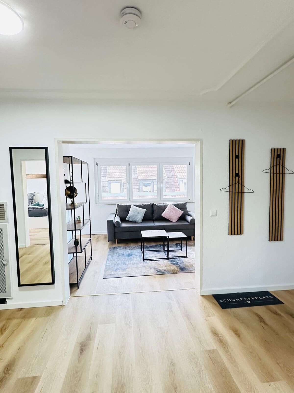 A modern living room with a sofa, coffee table, and a view through a glass door.