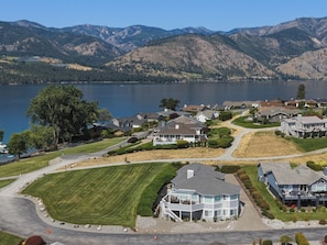 A residential area with houses, a lake, and mountains in the background.