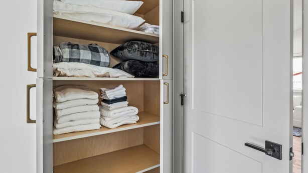 A wardrobe with multiple shelves, some with folded clothes and others empty. - NEW Downtown Sisters Luxe Retreat with Hot Tub + Firepit (Sisters)