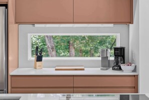 A kitchen with a window, a coffee maker, a knife block, and a bowl. - New Home + Guest House on Bike Trail (Bella Vista)