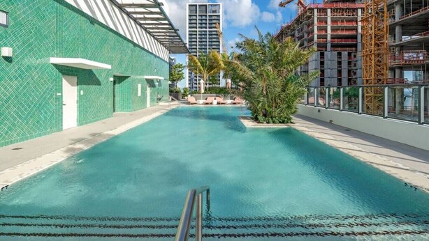 Piscina com vista desobstruída para os edifícios e canteiro de obras ao redor.