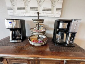 Un espace dédié au café, équipé de trois machines à café et d’un plateau de dosettes de café.