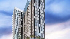 En moderne højhusbygning med flere altaner og en glasfacade.
