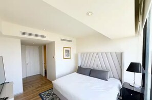 A modern hotel room with a large bed, a bedside table, a lamp, and a picture on the wall. - Apartment Andares - Wonderful 3-bedroom apartment with AC in charming Zapopan (Zapopan)