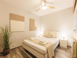 A hotel room with a bed, bedside tables, a ceiling fan, and a potted plant. - Bravissimo Pons i Martí Baix, 1-bedroom apartment (Girona)