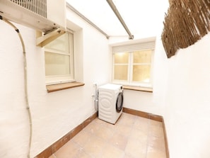 A laundry room with a washing machine, a window, and a ceiling vent. - Bravissimo Pons i Martí Baix, 1-bedroom apartment (Girona)