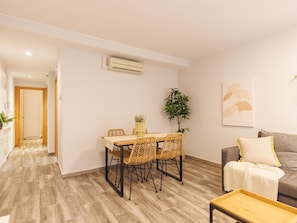 A modern living room with a dining area, a sofa, and a coffee table. - Bravissimo Pons i Martí Baix, 1-bedroom apartment (Girona)