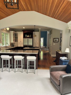 A spacious kitchen with a large island, wooden ceiling, and a view into the dining area. - Beautiful home in desirable Riverlocks neighborhood, walkable to Kennebunkport (Kennebunk)