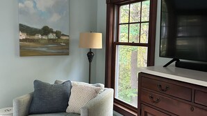 A living room with a sofa, a lamp, a painting, a window, and a television. - Beautiful home in desirable Riverlocks neighborhood, walkable to Kennebunkport (Kennebunk)