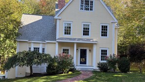 A two-story house with a front porch, a brick pathway leading to the entrance, and a well-maintained lawn. - Beautiful home in desirable Riverlocks neighborhood, walkable to Kennebunkport (Kennebunk)
