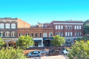 A street view with multiple buildings, including a bakery and a store with a sign that reads 'Baked Beans.' - Cozy Broughton Street Retreat | Walk to Everything (Savannah)