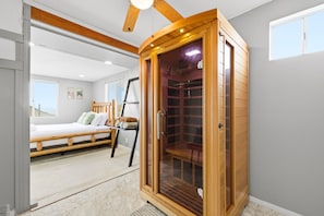 Una sauna amb una porta de fusta i una banca a l'interior.