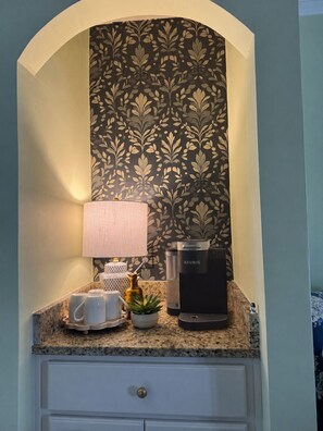 A kitchen counter with a coffee maker, a lamp, and a decorative plant. - The Magnolia Double En-Suite Townhome near Augusta National & Medical District (Augusta)