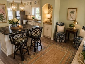 A kitchen with a marble island, bar stools, and a dining area with a patterned rug. - The Magnolia Double En-Suite Townhome near Augusta National & Medical District (Augusta)