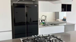 Ett modernt kök med en central köksö, apparater i rostfritt stål och en stilren design.