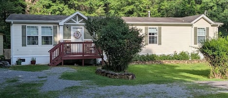A two-story house with a front porch and a stone wall.