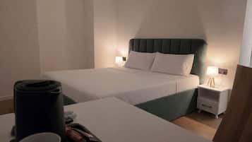A hotel room with a bed, bedside tables, a coffee maker, and a tray with snacks.