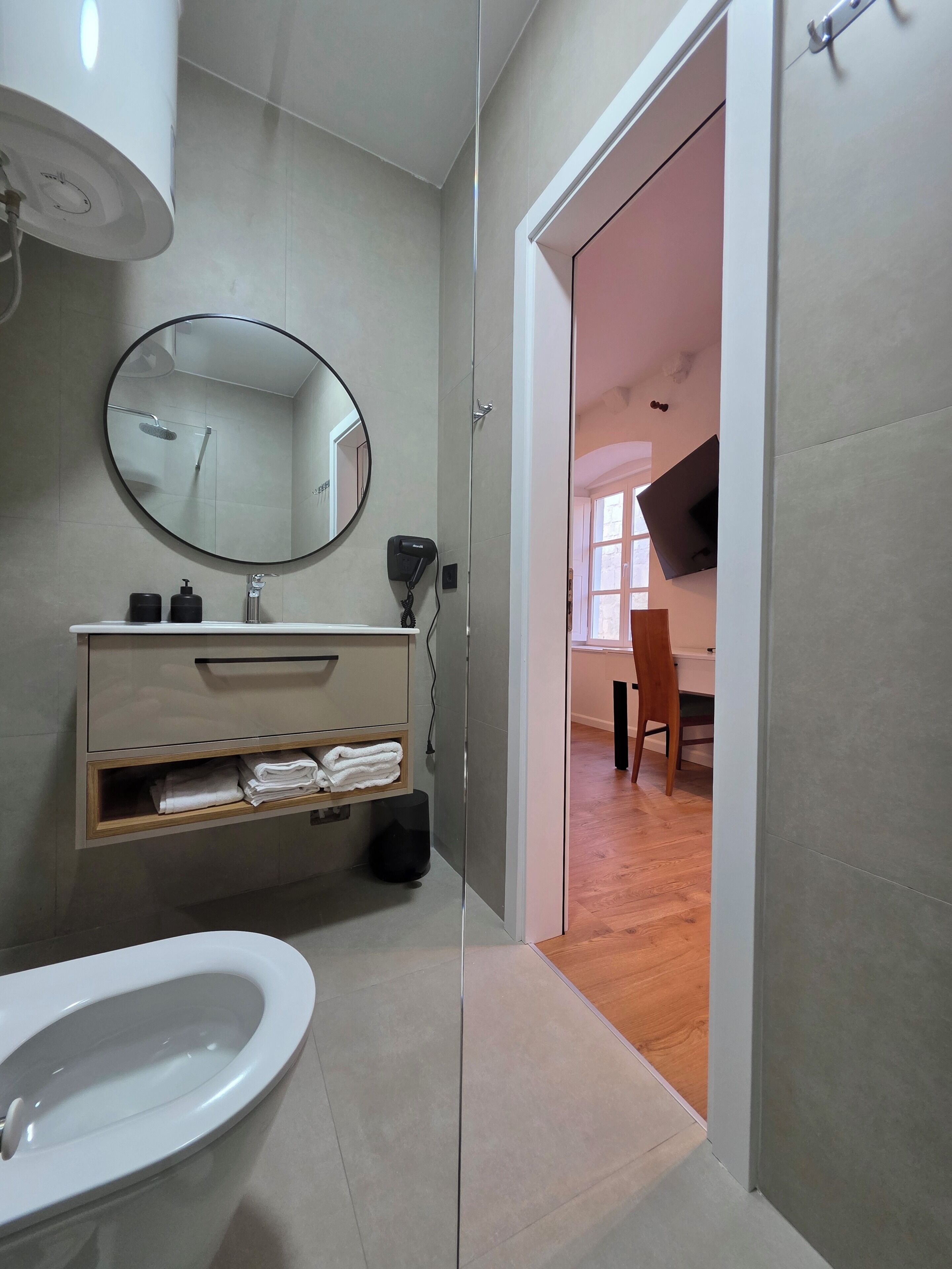 A modern bathroom with a toilet, sink, and mirror.