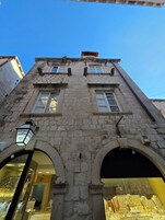 Um edifício de pedra com janelas em arco e entrada de loja.