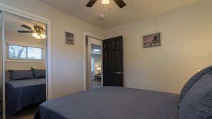 A bedroom with a bed, a door, a ceiling fan, and a window. - Entire Hobart Home (Hobart)