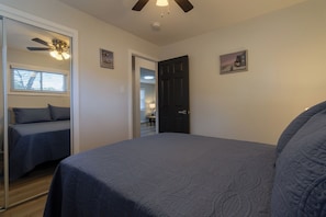 A bedroom with a bed, a door, a ceiling fan, and a window. - Entire Hobart Home (Hobart)