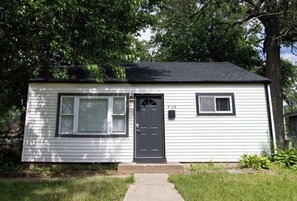 A single-story house with a dark front door, two windows with shutters, and a small front yard. - Entire Hobart Home (Hobart)