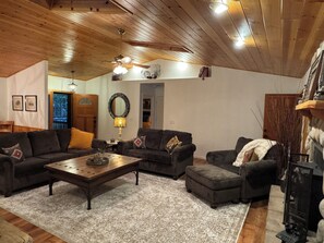 Ein gemütliches Wohnzimmer mit Holzbalken, einem Kamin und einem großen Spiegel an der Wand.