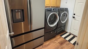 A compact kitchen with stainless steel appliances, wooden cabinets, and a striped rug. - Adorable 3-bedroom cabin in Pinetop Country Club, newly renovated. Pets Welcome! (Pinetop Country Club)