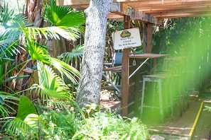 A wooden structure with a sign indicating closure and a re-opening time. - Butler Beach Getaway | Tiki Bar + Fenced Yard! (St. Augustine)