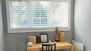 A room with a wooden desk, a black chair, a window with blinds, and a radiator. - Casa Sul Lago Spacious 5-bedroom house in charming Delavan w/AC Firepit Deck (Delavan)