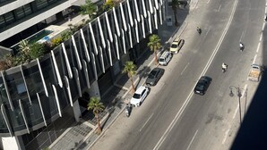 Un grattacielo con diversi piani, una strada curva e alcuni veicoli.