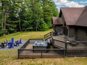 A log cabin with a deck, outdoor seating, and a hot tub. - Jay Brook Lodge | Sleeps 16 | Hot Tub | Game Room (Jay)