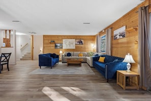 A living room with a sofa, armchair, coffee table, and lamp. - Buckeye Ranch: Lovely mountain house/ 20 min from Yosemite/ 6 min from Bass lake (Oakhurst)