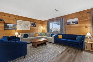 Ein gemütliches Wohnzimmer mit einer Sofagarnitur, einem Couchtisch und einem Teppich.