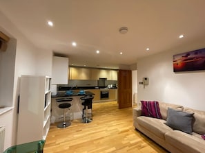 Eine moderne Wohnung mit Küche, Essbereich und Wohnzimmer.